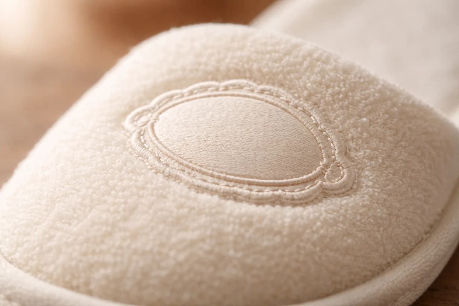 Embroidered logo detail on hotel slipper